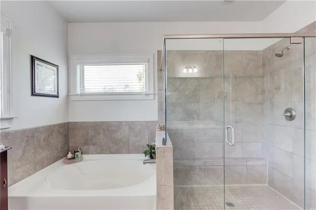 a white bath tub sitting next to a shower