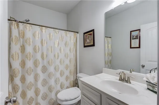 a bathroom with a sink a toilet and shower curtain