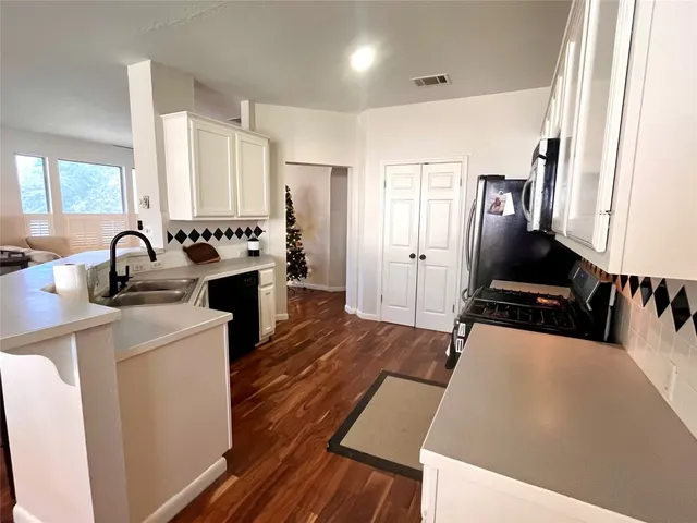 a kitchen with sink a refrigerator and cabinets