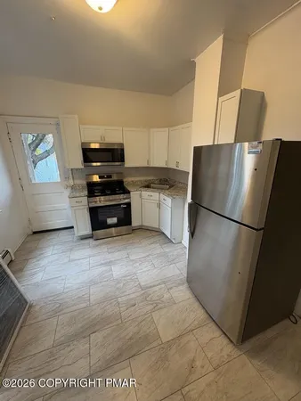 a kitchen with a refrigerator and a stove