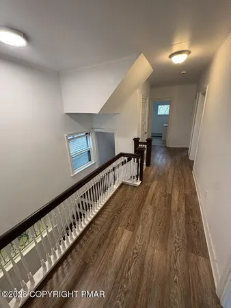 a view of a hallway with wooden floor
