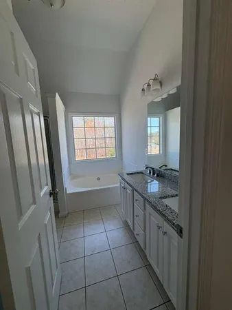 a bathroom with a granite countertop sink a toilet a mirror and vanity