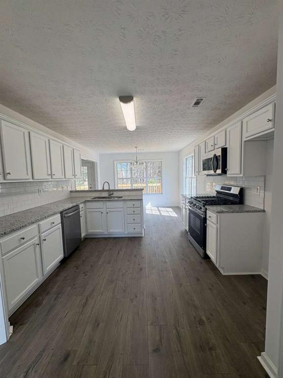 500 Shiver Boulevard Covington, GA 30016 - Photo 10 of 25 a kitchen with stainless steel appliances a sink cabinets and wooden floor