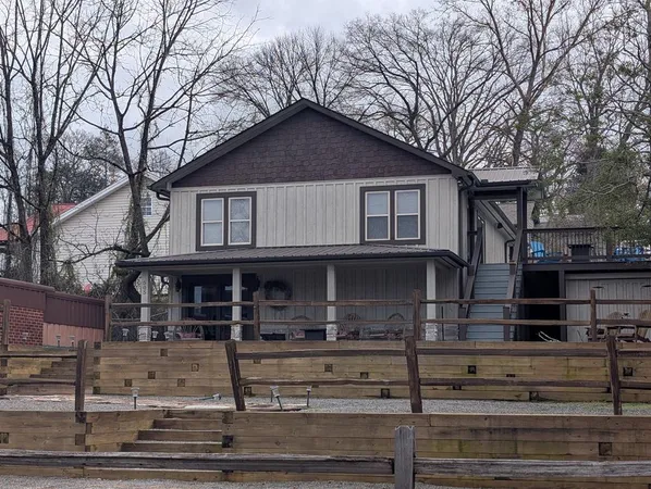 a front view of a house with garage and trees