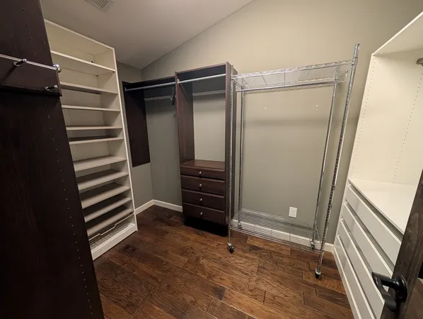a view of walk in closet with empty racks