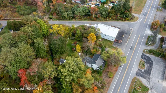 an aerial view of residential house with outdoor space and trees all around