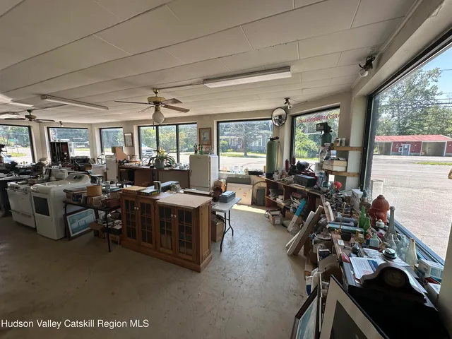 a living room with furniture a flat screen tv and a large window
