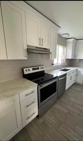 a kitchen with granite countertop white cabinets and white appliances