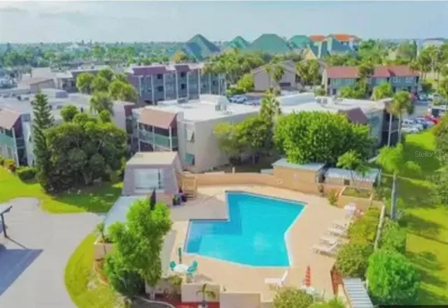 an aerial view of a house with a garden and lake view
