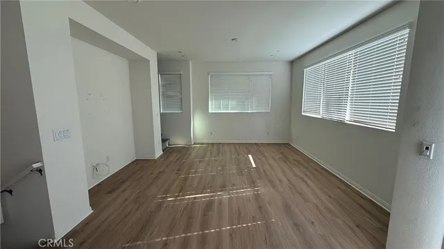 a view of a room with wooden floor and windows