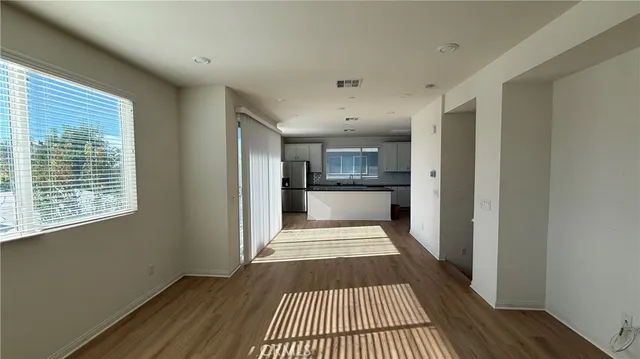 a view of a room with wooden floor and a kitchen
