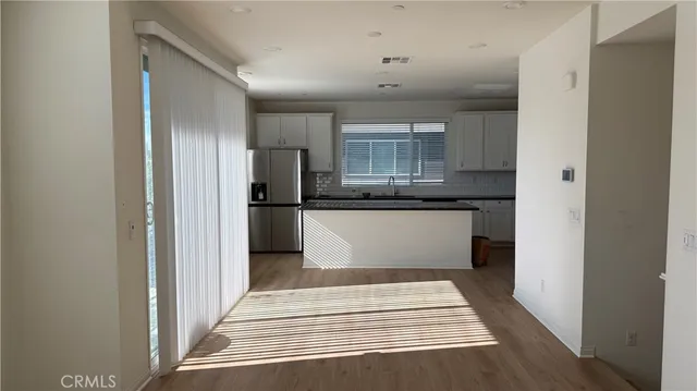 a view of a kitchen with a sink and an empty room