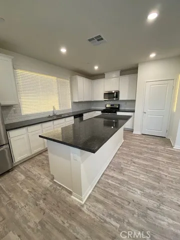 a kitchen with stainless steel appliances granite countertop a sink and a stove