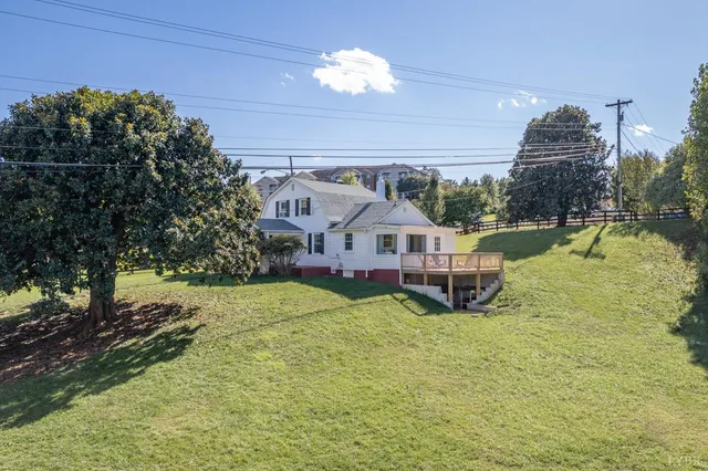 an aerial view of a house with a yard and lake view