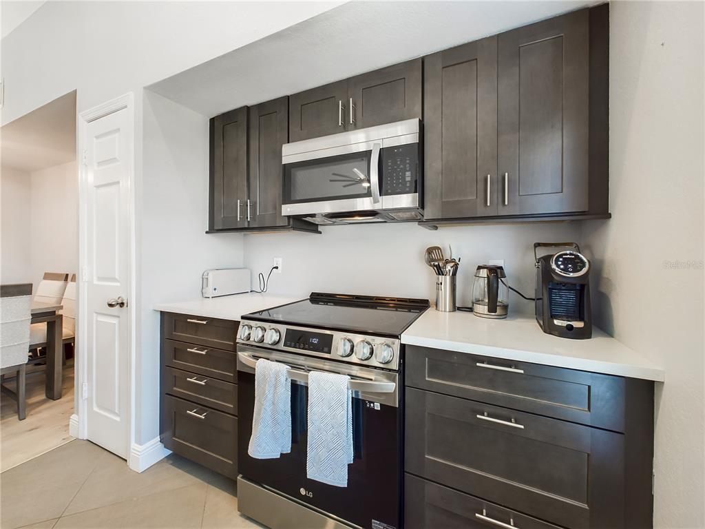 5521 Rosehill Road, Unit 203 Sarasota, FL 34233 - Photo 11 of 51 a kitchen with stainless steel appliances granite countertop a stove and a microwave