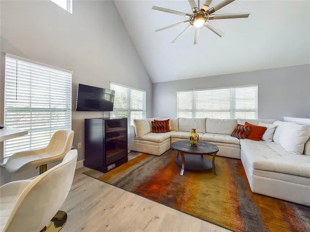 a living room with furniture a flat screen tv and a large window