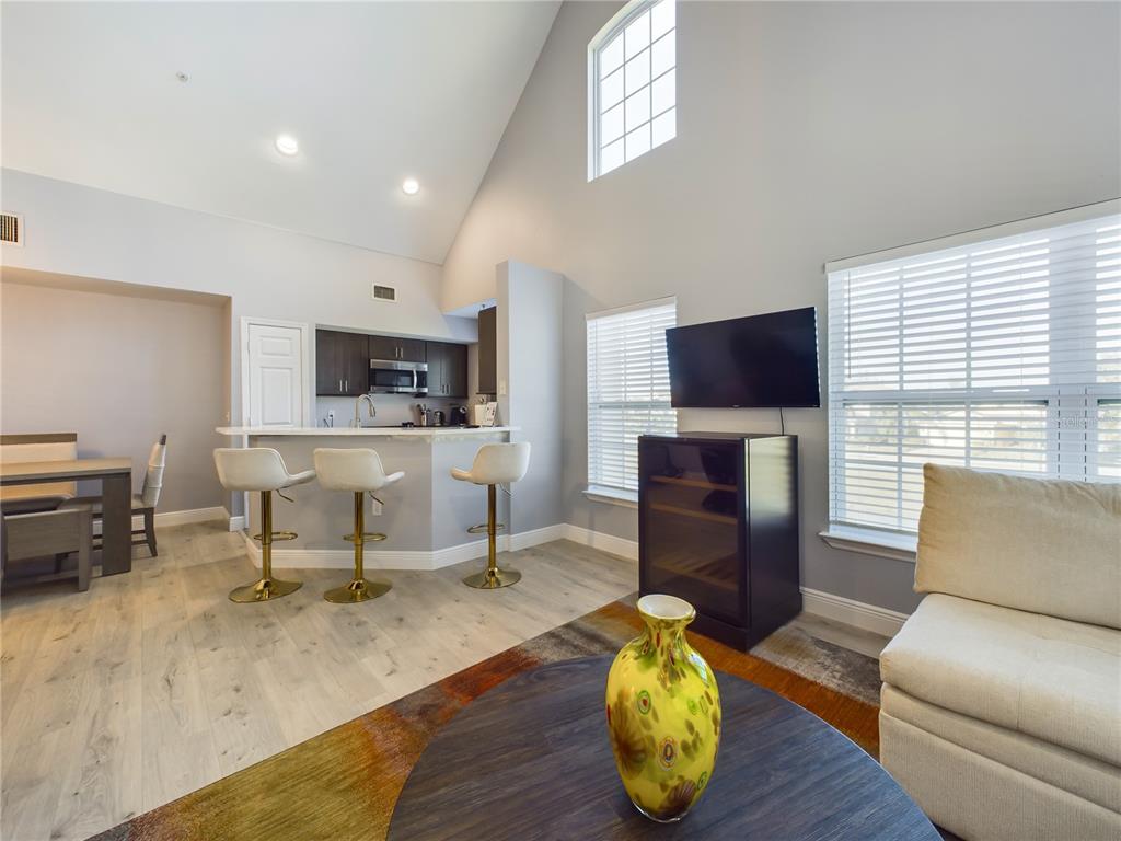 5521 Rosehill Road, Unit 203 Sarasota, FL 34233 - Photo 14 of 51 a living room with furniture a fireplace and a flat screen tv