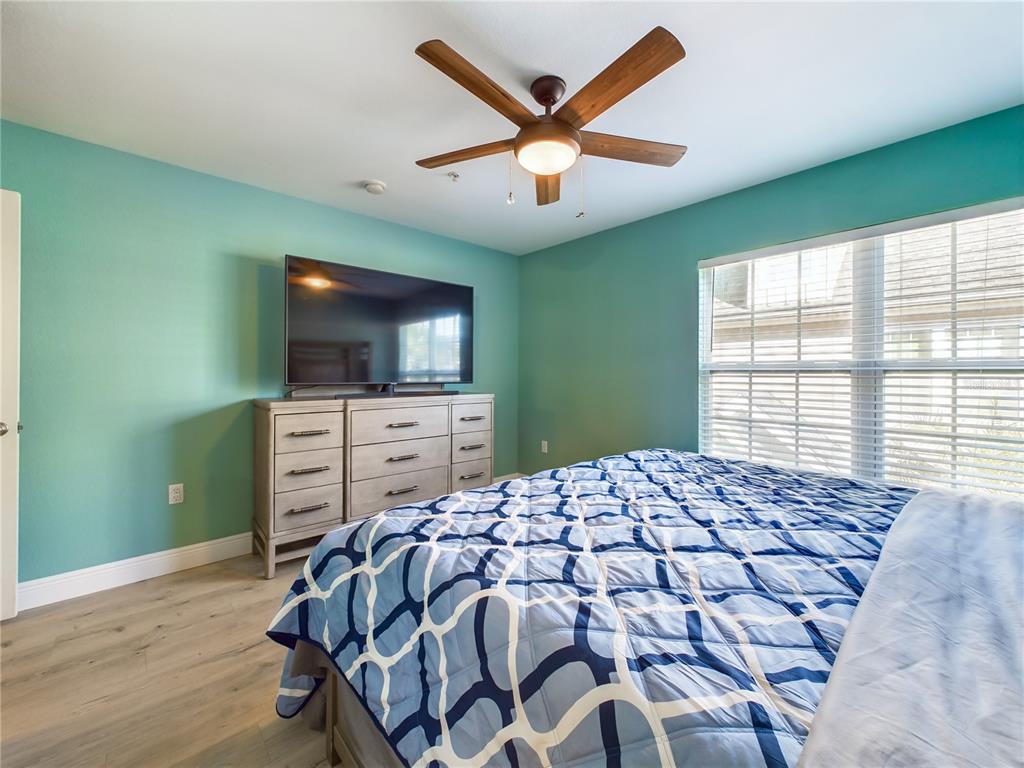 5521 Rosehill Road, Unit 203 Sarasota, FL 34233 - Photo 15 of 51 a bed sitting in a bedroom next to a window and a flat screen tv