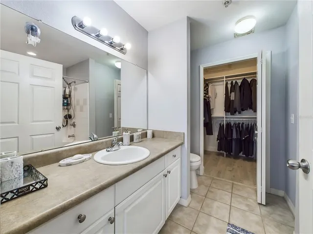 a spacious bathroom with a granite countertop sink and a mirror