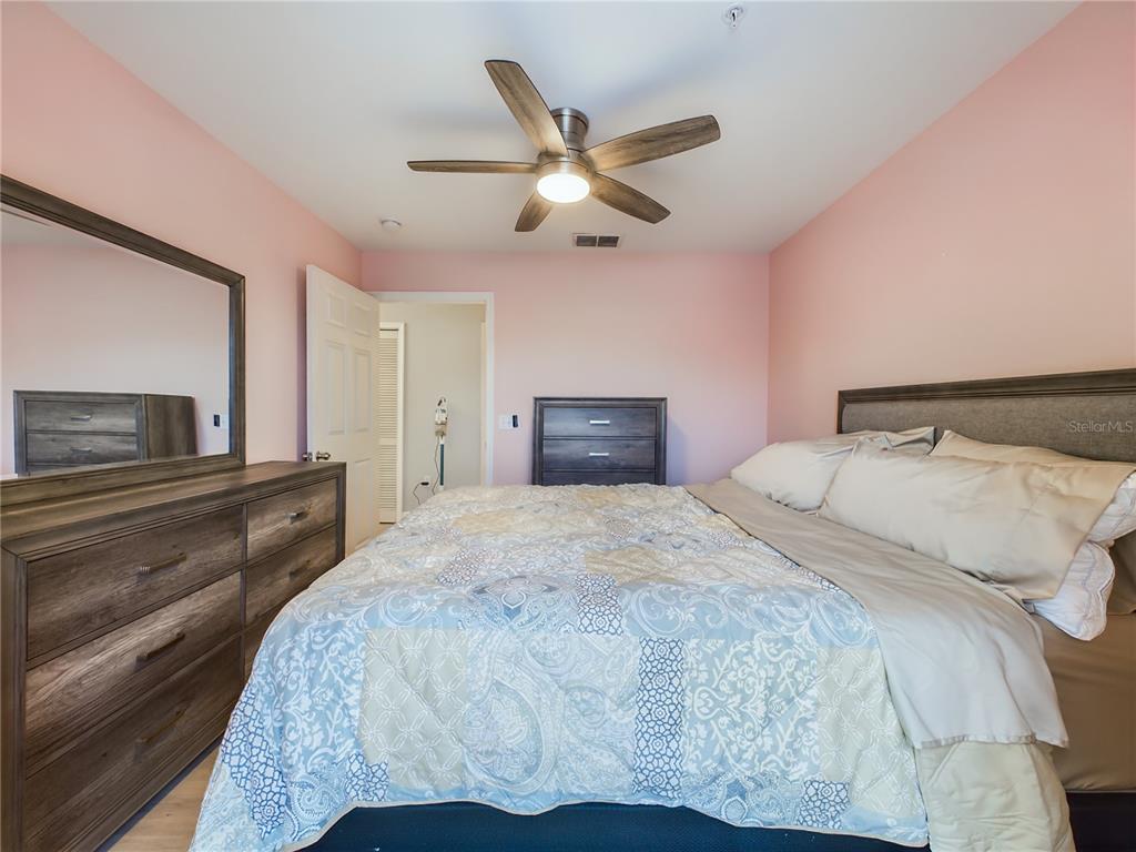5521 Rosehill Road, Unit 203 Sarasota, FL 34233 - Photo 25 of 51 a bedroom with a large bed and a chandelier