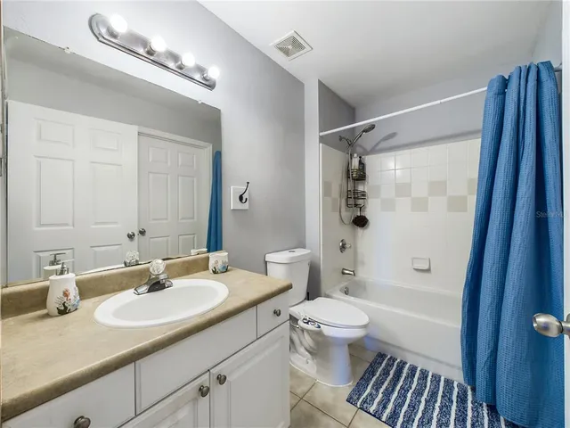 a bathroom with a sink a toilet a mirror and shower