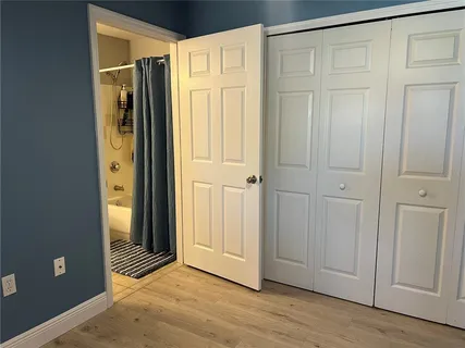 a view of a hallway with wooden floor and entryway