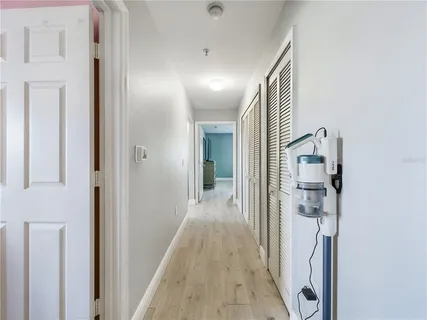 a view of a hallway with wooden floor and staircase