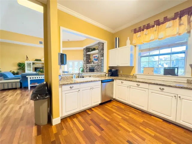 a large white kitchen with granite countertop white cabinets and white appliances
