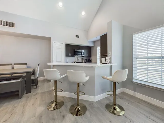 a kitchen with cabinets and chairs