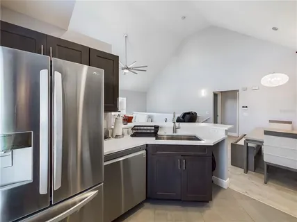 a kitchen with stainless steel appliances a sink a stove a refrigerator and cabinets