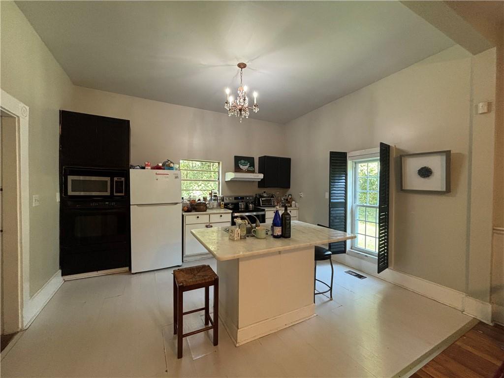 1090 Forrest Avenue Stone Mountain, GA 30083 - Photo 4 of 13 a kitchen that has a refrigerator and a stove top oven