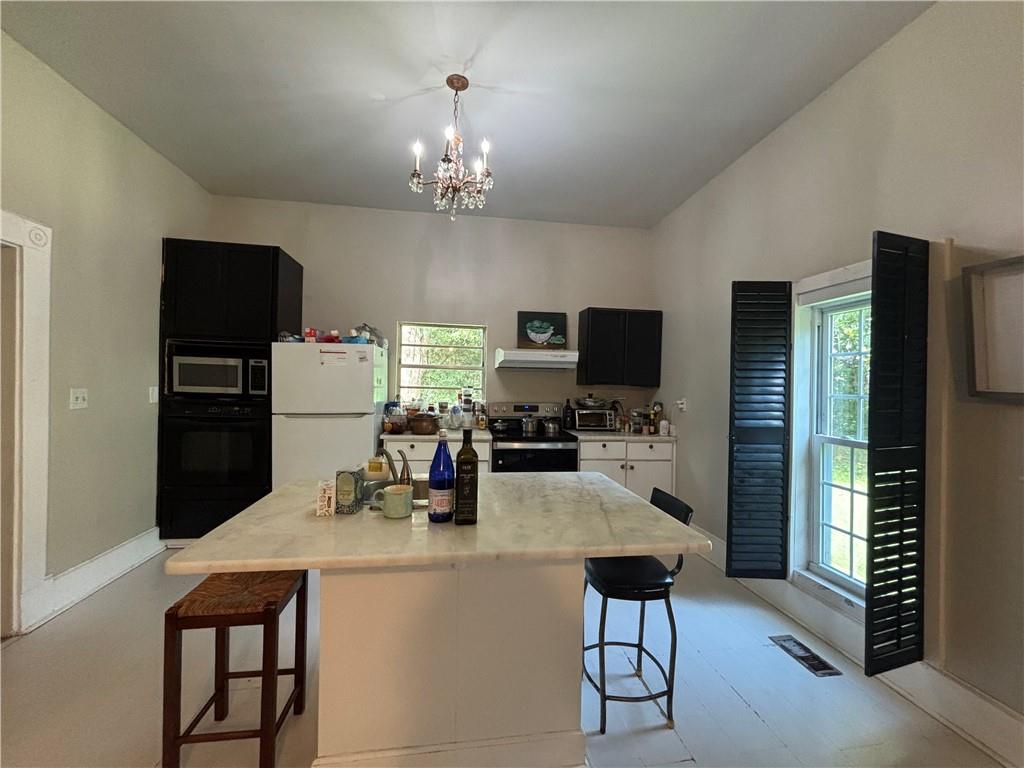 1090 Forrest Avenue Stone Mountain, GA 30083 - Photo 5 of 13 a kitchen with stainless steel appliances a dining table and chairs