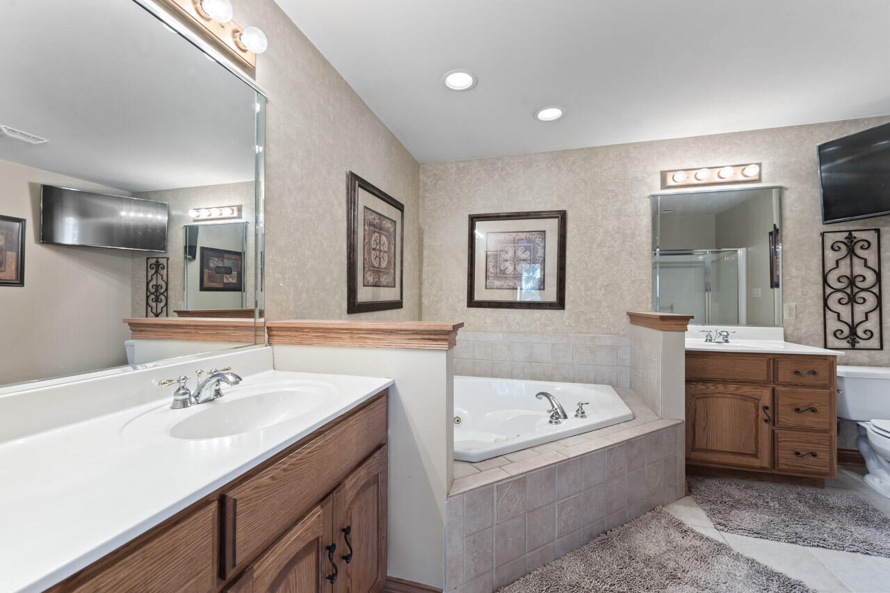 205 North Elgin Street Griffith, IN 46319 - Photo 27 of 43 a bathroom with a tub a double vanity sink and mirror