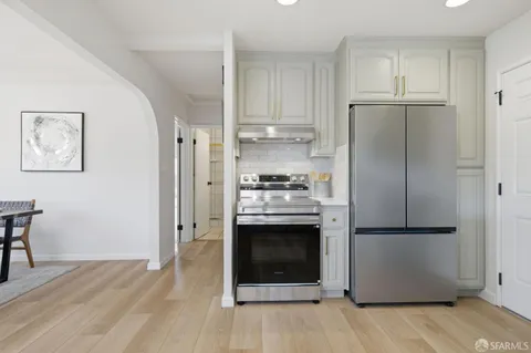 a kitchen with stainless steel appliances granite countertop a refrigerator and a stove top oven