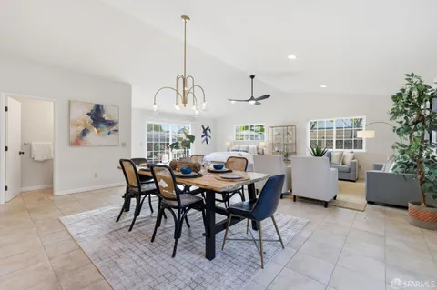 a view of a dining room and livingroom with furniture wooden floor a chandelier