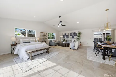 a spacious bedroom with a bed a table and chairs