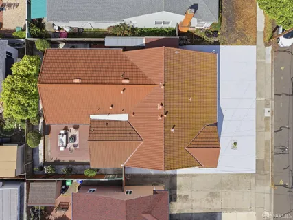 an aerial view of a house with yard and seating space