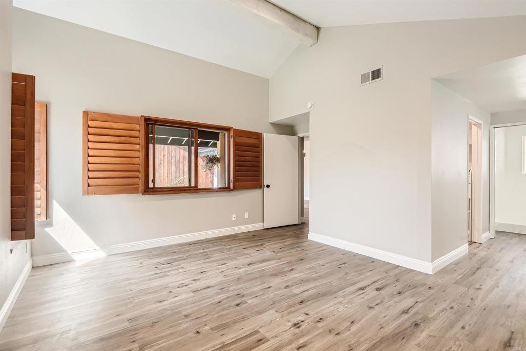 808 Hitching Post Road Vista, CA 92081 - Photo 17 of 29 a view of an empty room with wooden floor and a window