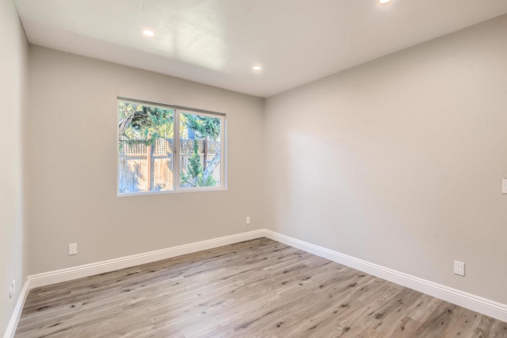 808 Hitching Post Road Vista, CA 92081 - Photo 22 of 29 an empty room with wooden floor and windows
