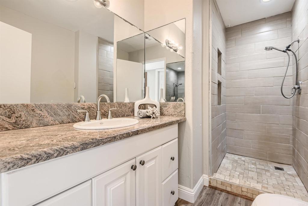 808 Hitching Post Road Vista, CA 92081 - Photo 24 of 29 a bathroom with a granite countertop sink and a mirror