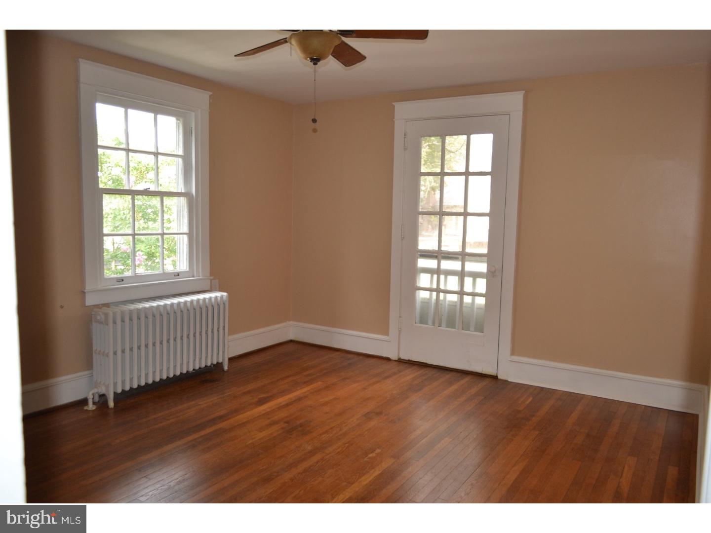 129 Walsh Road Lansdowne, PA 19050 - Photo 14 of 25 an empty room with wooden floor and windows