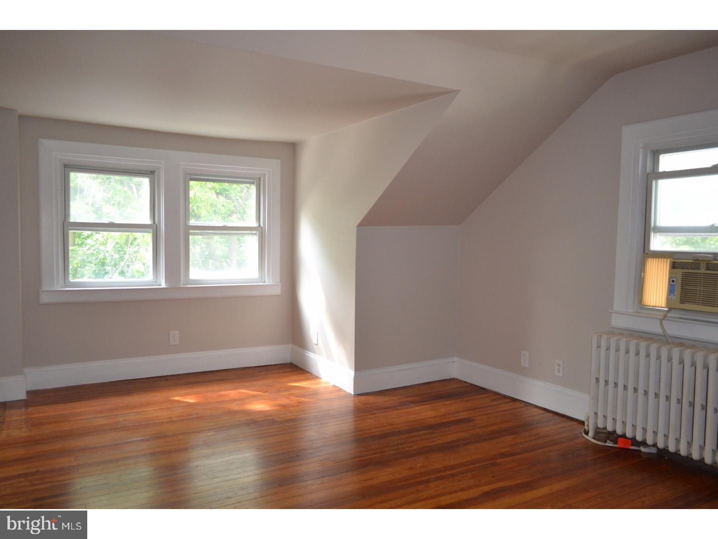 129 Walsh Road Lansdowne, PA 19050 - Photo 19 of 25 an empty room with wooden floor and windows