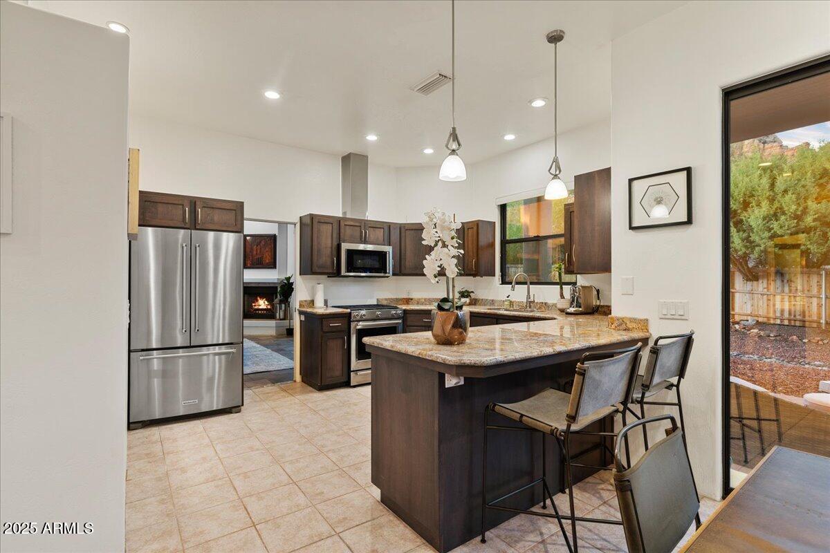 50 Ranch Road Sedona, AZ 86336 - Photo 47 of 51 a kitchen with stainless steel appliances a sink a stove a refrigerator cabinets and a dining table