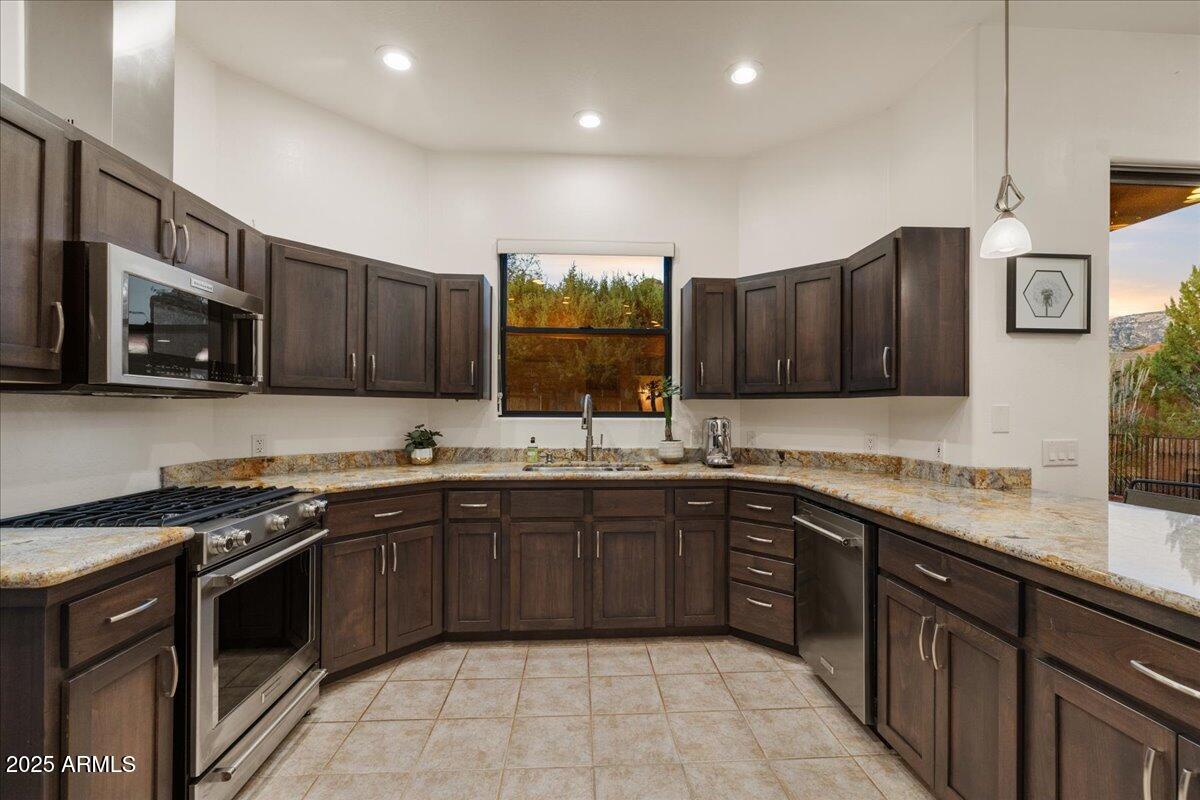 50 Ranch Road Sedona, AZ 86336 - Photo 48 of 51 a kitchen with stainless steel appliances granite countertop wooden cabinets a sink dishwasher a stove and a refrigerator