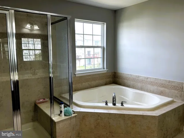 a white bath tub sitting in a bathroom next to a window