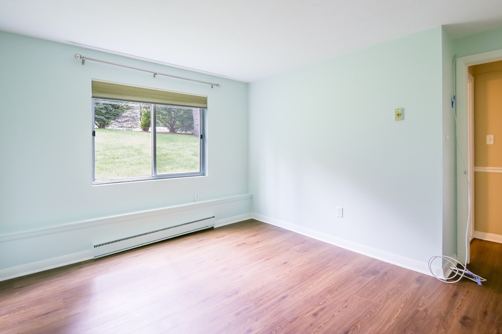 74 Beach Street, Unit 12 Woburn, MA 01801 - Photo 12 of 14 an empty room with wooden floor and windows