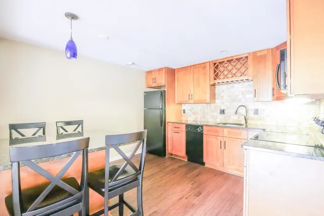 a kitchen with a sink cabinets and wooden floor