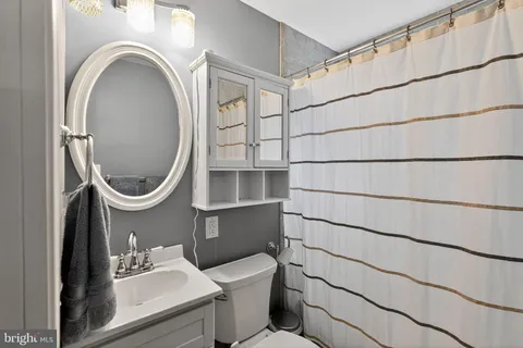 a bathroom with a sink a toilet and a mirror