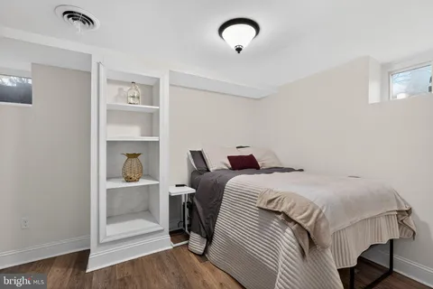 a bedroom with a bed and a wooden floor