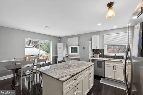 a kitchen with a stove a sink a dining table and chairs